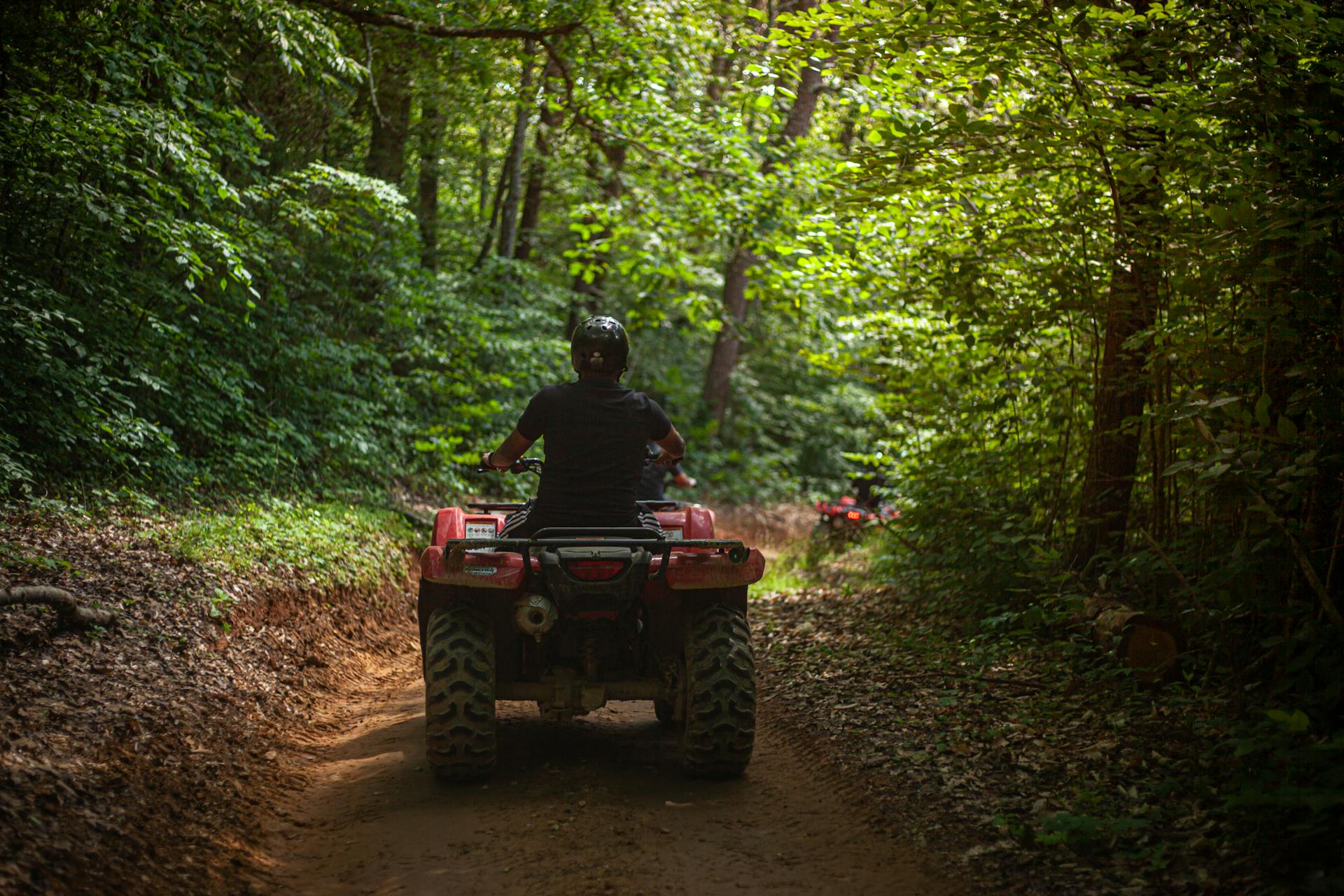 ATV riders on a forested trail in the Ozark National Forest